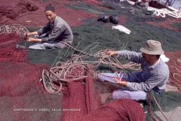 Image du Maroc Professionnelle de  Quelques ouvriers s'activent à réparer les filets de pêche sur un des quais au port d'Agadir, ville située au sud du Maroc, Vendredi 23 Août 2002. (Photo / Abdeljalil Bounhar)

 